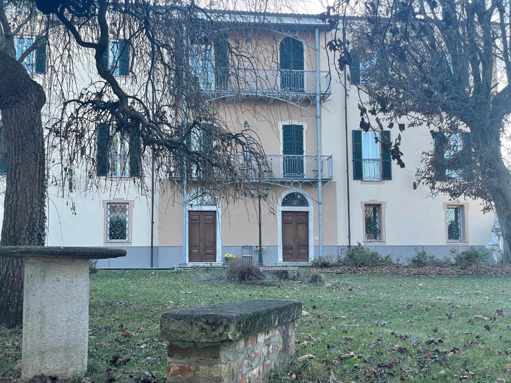 een groot wit gebouw met een boom ervoor bij Villa Durando in Mondovì