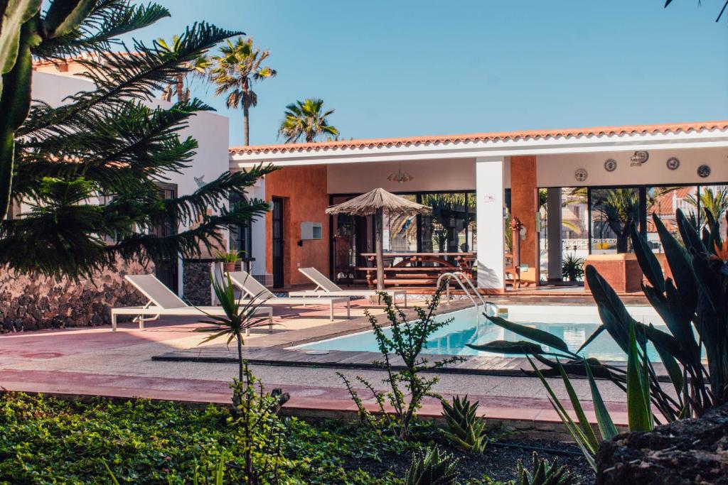 eine Villa mit einem Pool und einem Haus in der Unterkunft La Concha ADULTS ONLY CORRALEJO in Corralejo