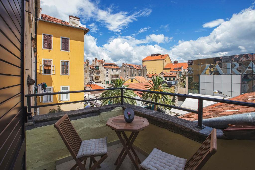 a balcony with two chairs and a table on a building at Bed & Atmosphere Rooms in Split