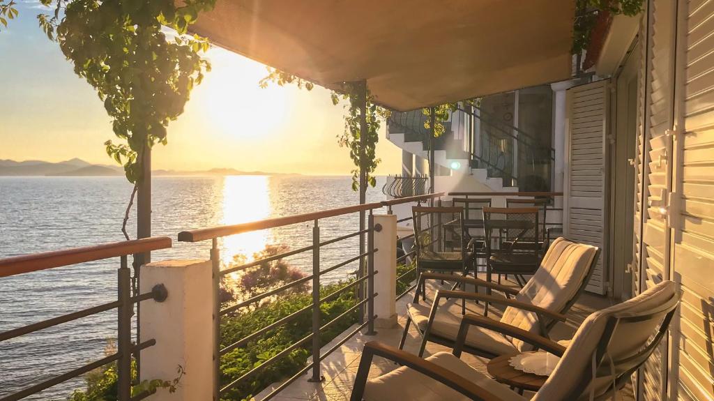 d'un balcon avec des chaises et une vue sur l'eau. dans l'établissement Sunset Apartment Padrele, à Bibinje