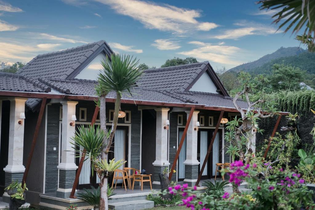 a house with a black roof and some plants at The Lava Bali Villa and Hot Spring in Kintamani