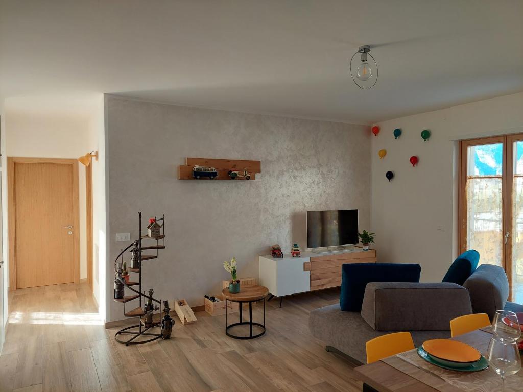 a living room with a couch and a tv at La bougainville - luxury apartment in Nago-Torbole