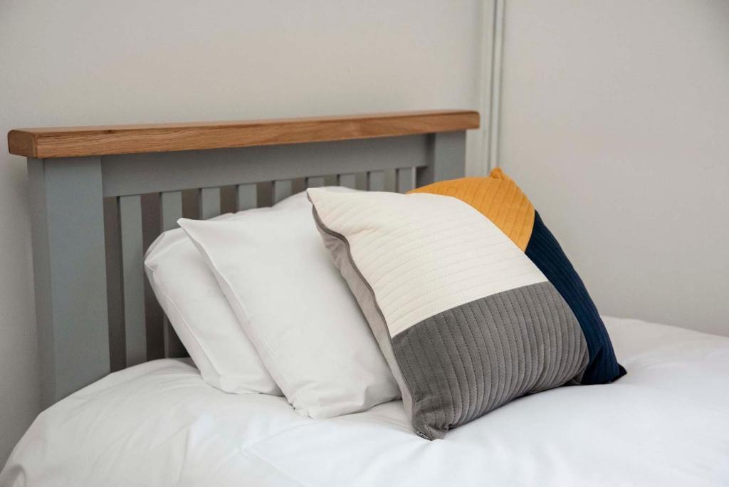 a pile of pillows sitting on top of a bed at Northern Lodge in Newport