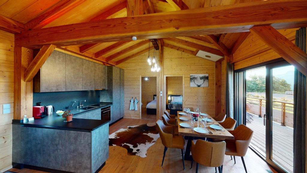 a kitchen and dining room with a table and chairs at Woodland Village Anzère in Ayent