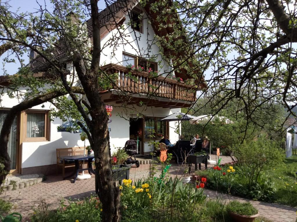 a house with a balcony in a garden at Ferienwohnung Beate Engelhardt in Kleinern