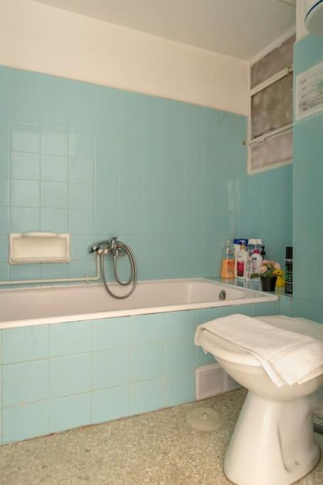 niebieska łazienka z toaletą i wanną w obiekcie Eχquisite apt in Acropolis-plaka/vaccinatedHost w Atenach