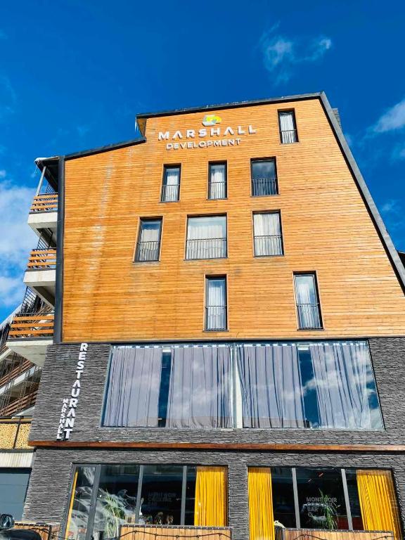 a building with a sign on the side of it at Marshall Apartment 202 in Gudauri