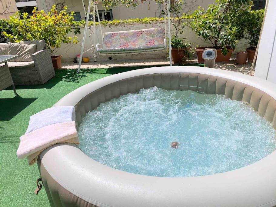 a jacuzzi tub in a backyard with a swing at Amazing 3BDR Apt with Unique Roof Garden in Plaka in Athens