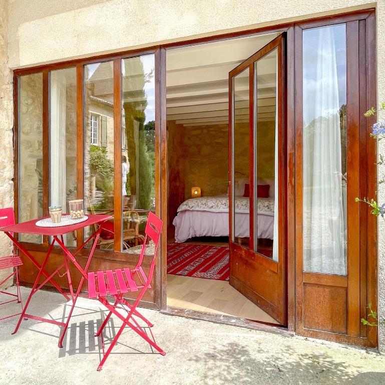 eine Terrasse mit einem Tisch und Stühlen sowie ein Schlafzimmer in der Unterkunft Le Tilleul in Grézillac