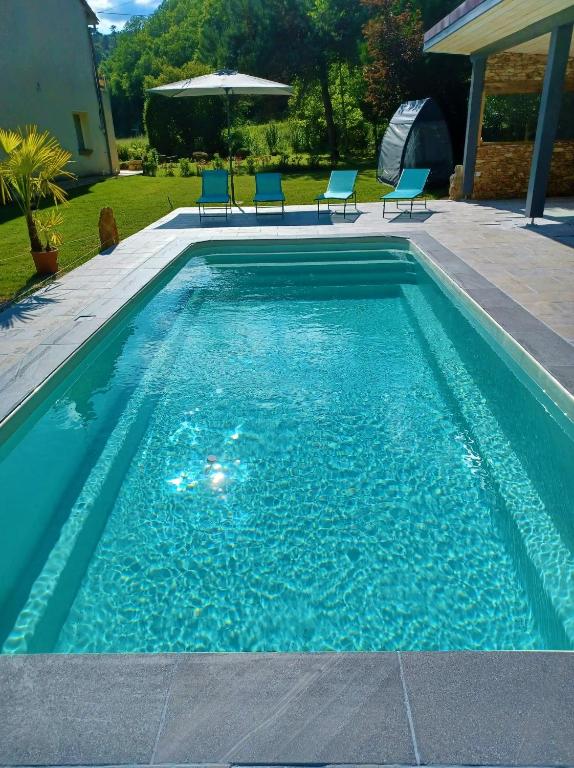 - une piscine avec des chaises bleues dans la cour dans l'établissement Le clos Le Roc Rouge, à Castels