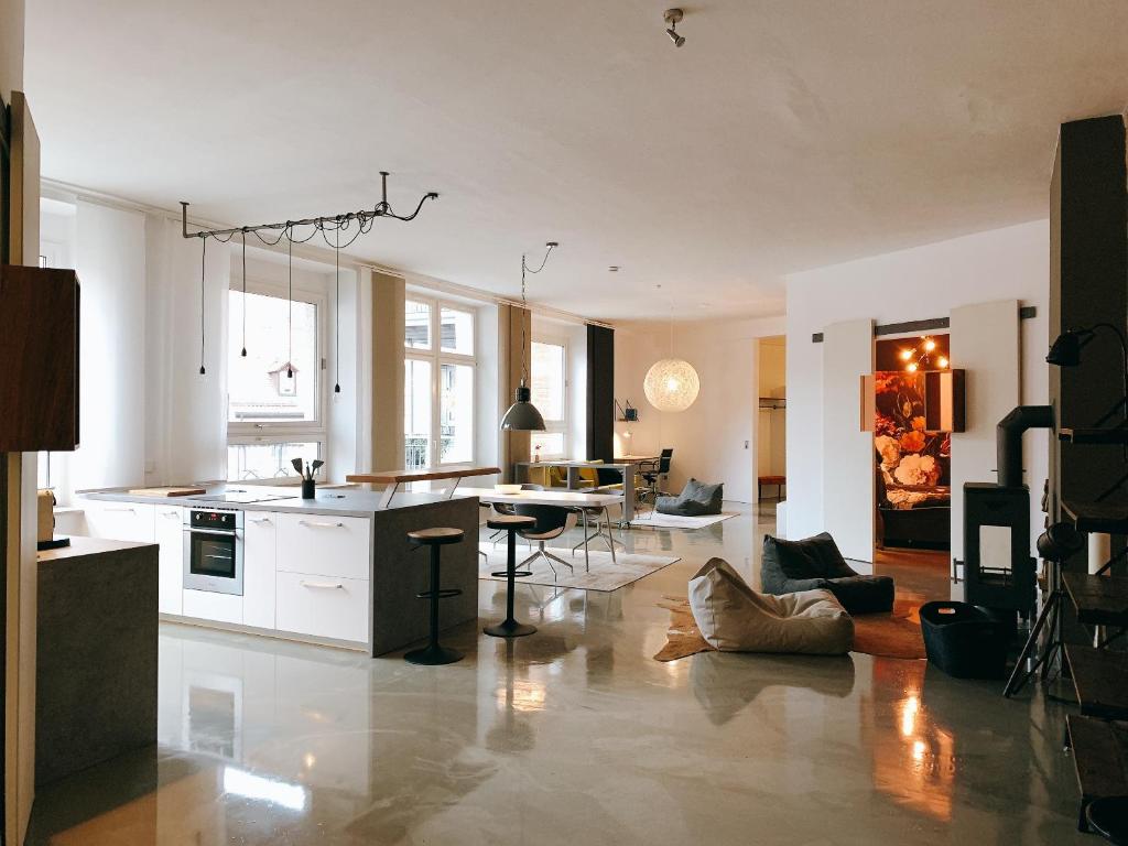 eine große Küche und ein Wohnzimmer mit einem Tisch in der Unterkunft GOHO Loft in Nürnberg