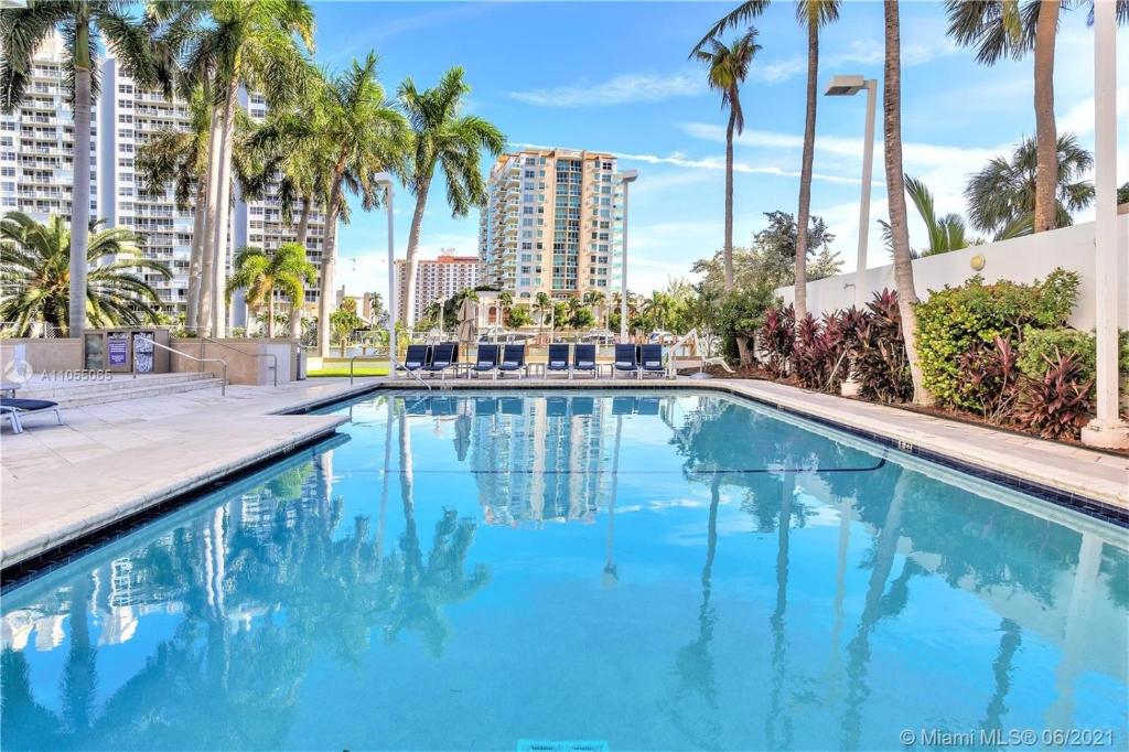 uma piscina com palmeiras e edifícios em 1 Bedroom Suite at GalleryOne condo em Fort Lauderdale