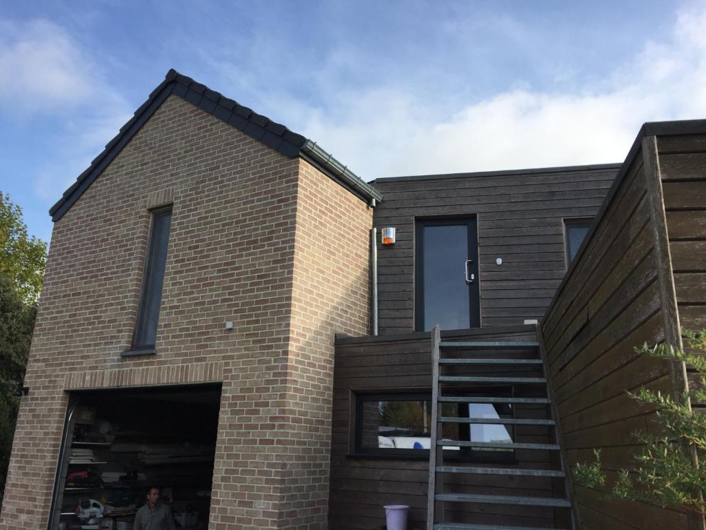 a brick house with a staircase in front of it at Le temps d’une balade. in Olne