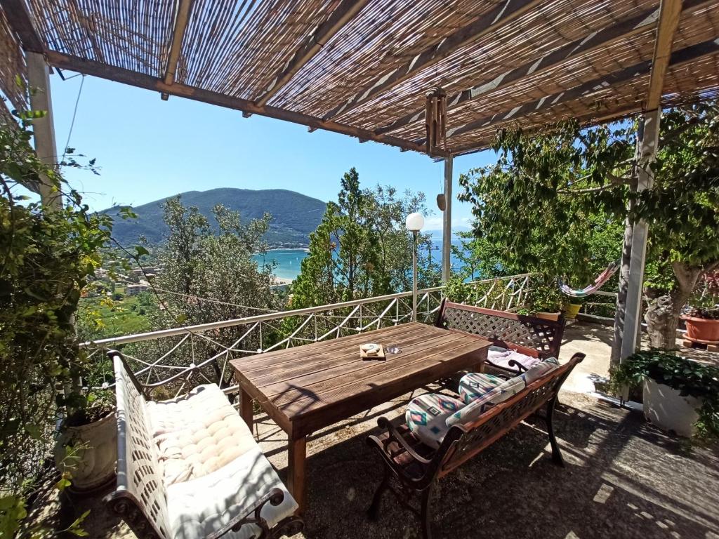 a wooden table and chairs on a balcony with a view at Heras Garden in Vasiliki