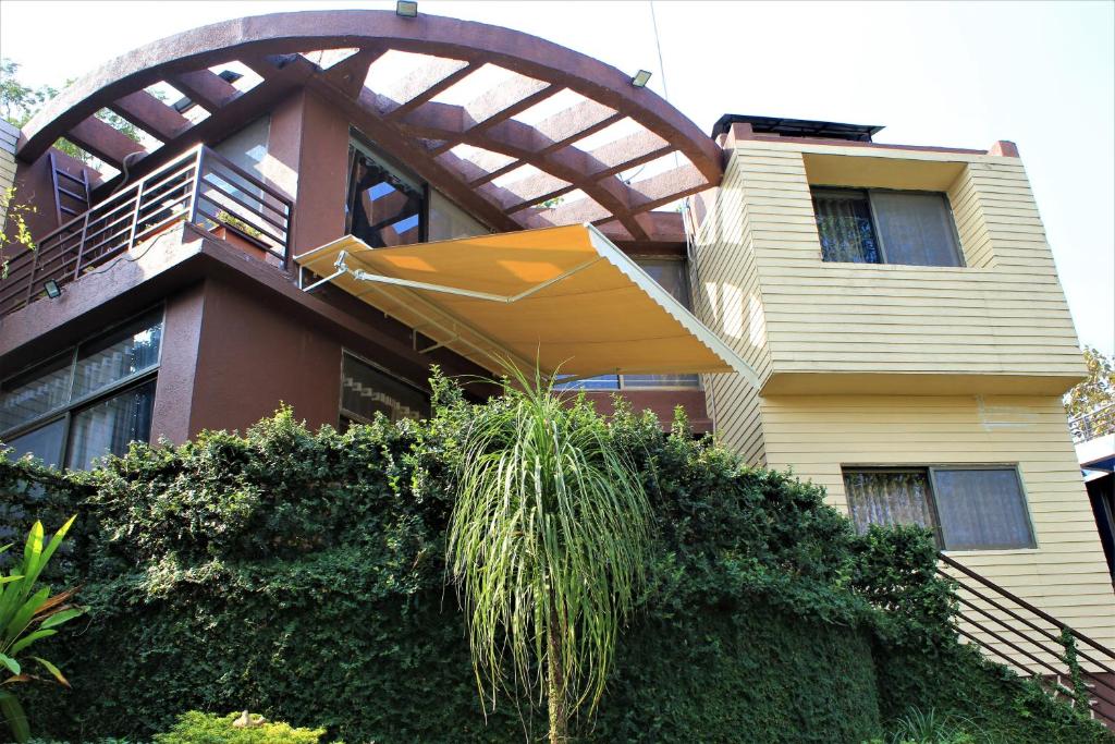 a house with an umbrella hanging off the side of it at Karjat Villa (3 BHK) With Garden Amidst Nature in Karjat