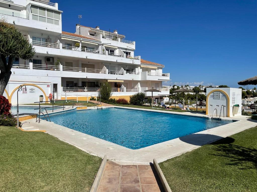 a swimming pool in front of a large building at Sea View Riviera- 4 bed apartment in Riviera del Sol with beautiful sea view! in La Cala de Mijas