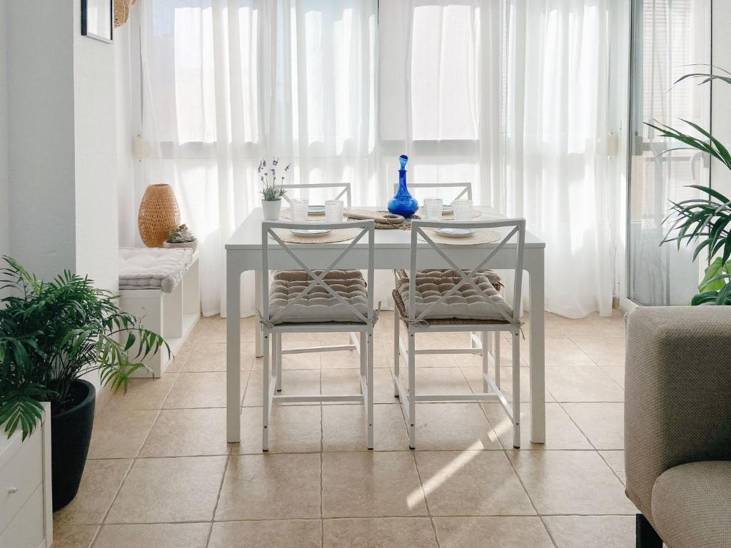 a dining room table with two stools and a table at Apartament Ampolla Port in L'Ampolla