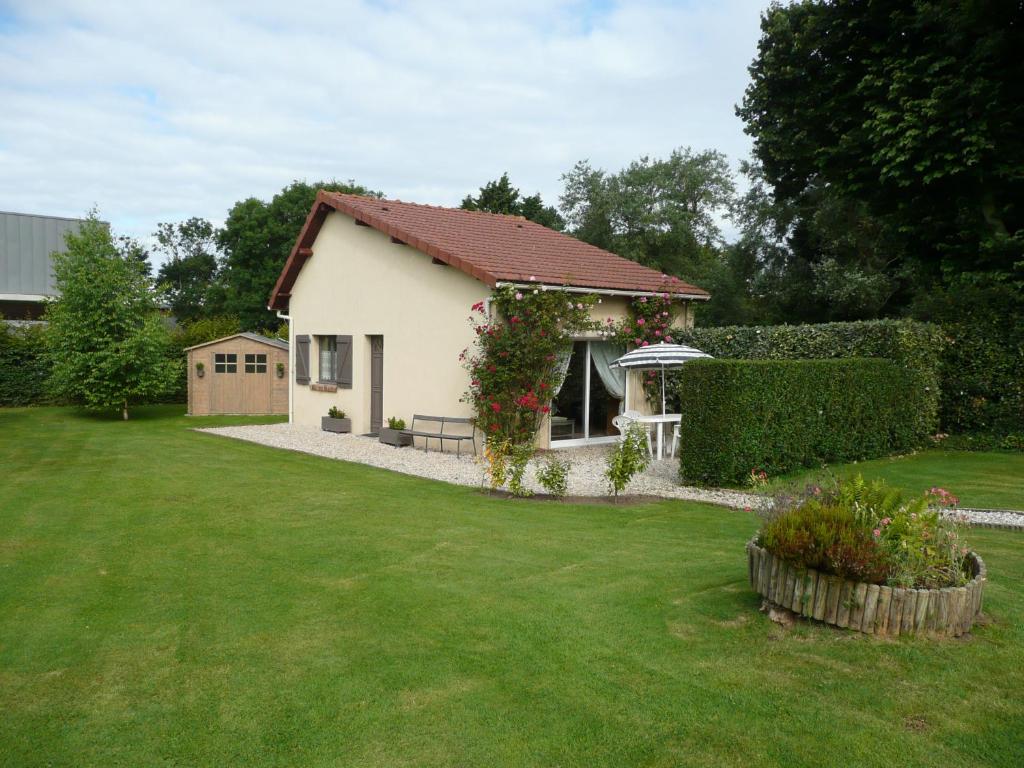 ein kleines weißes Haus mit einem grünen Hof in der Unterkunft Gîte berneval le grand in Berneval-le-Grand