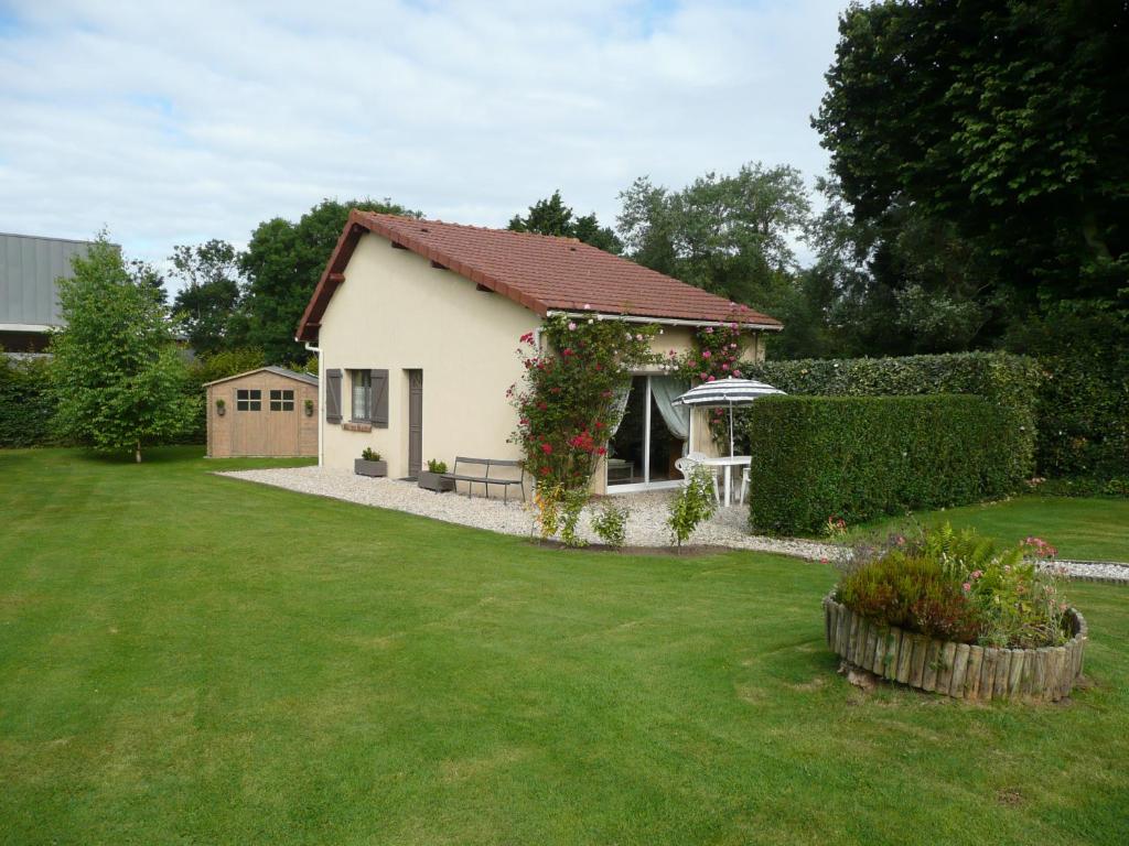a small white house with a green yard at Gîte berneval le grand in Berneval-le-Grand