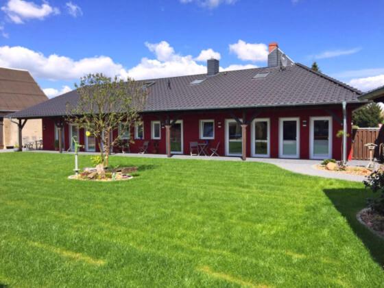 a house with a green lawn in front of it at Pension Ebert‘s Hof in Pirow