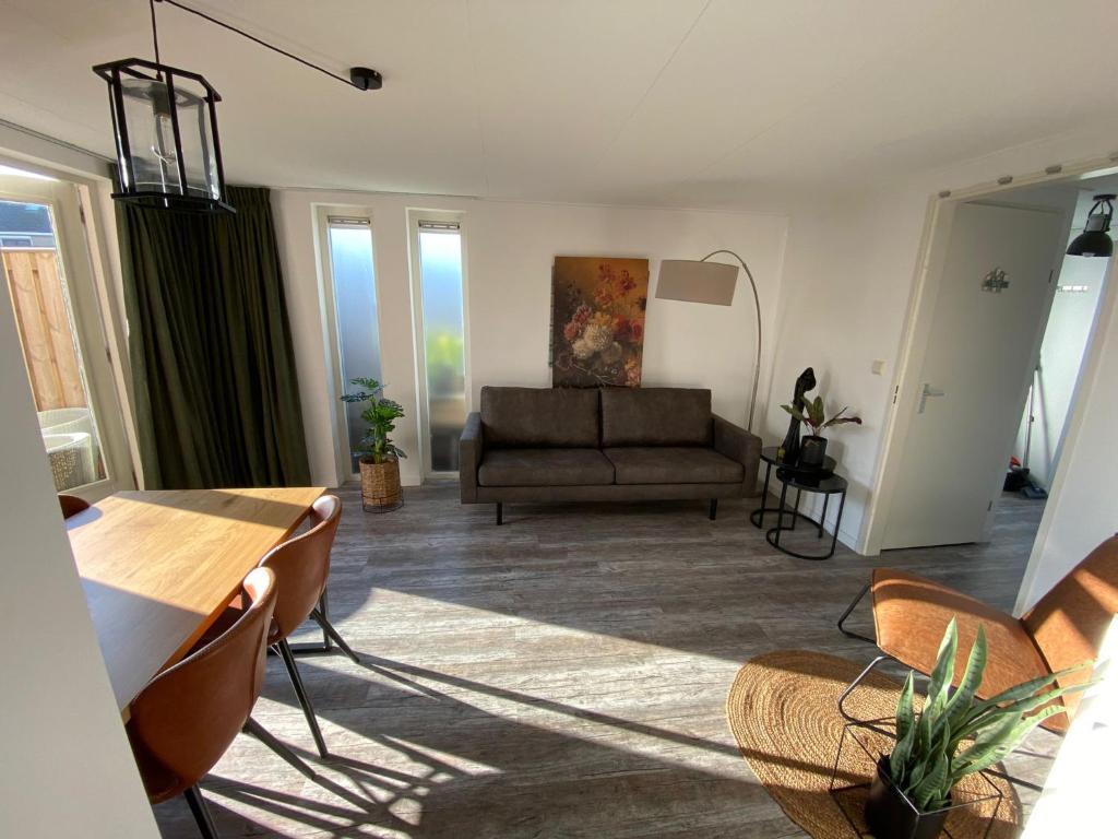 - un salon avec un canapé, une table et des chaises dans l'établissement Vakantiewoning Zwinstraat Zoutelande, à Zoutelande