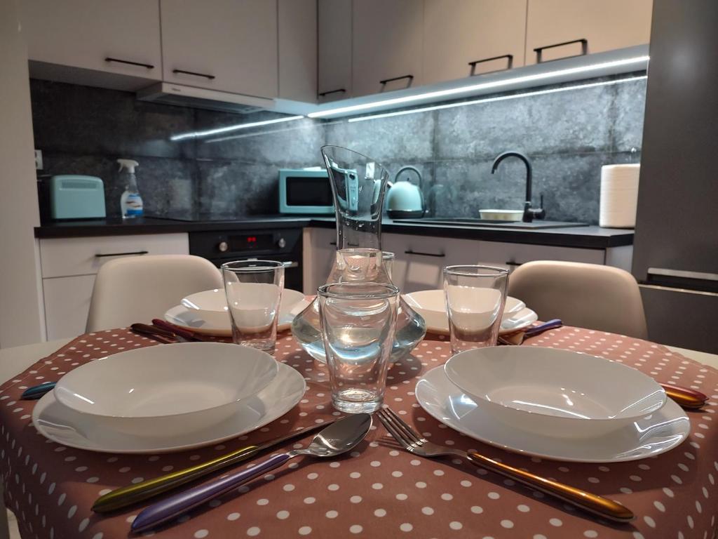 uma mesa com pratos e copos em cima de uma cozinha em Apartament Rumia Trójmiasto Kaszuby em Rumia