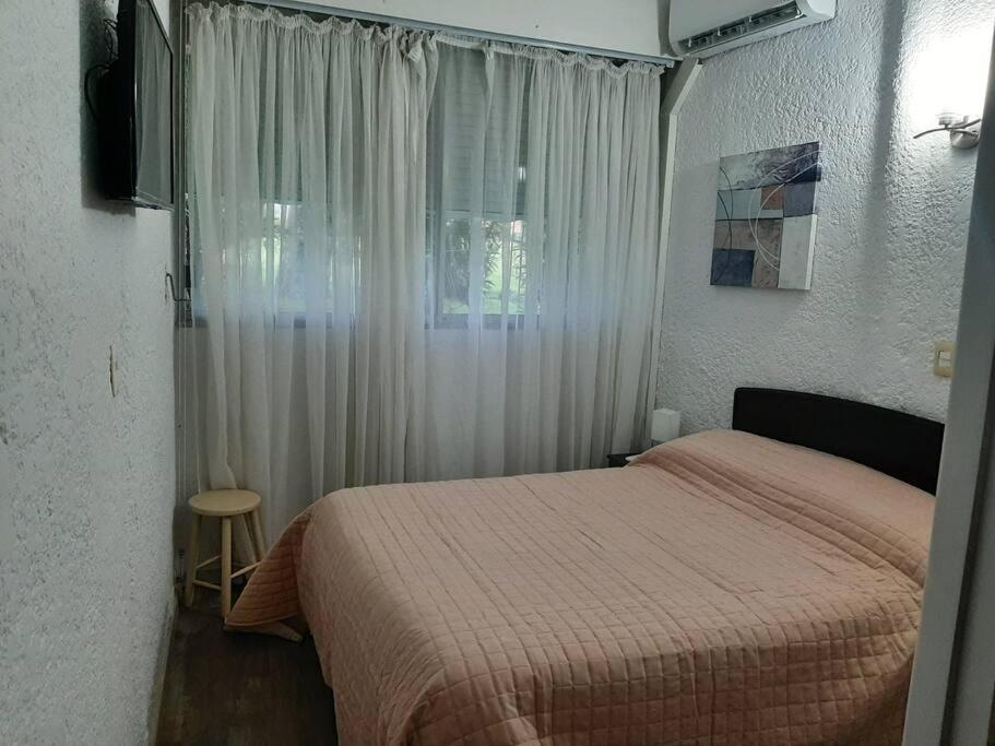 Habitación pequeña con cama y ventana en Apartamento con entrada independiente y jardín, en Punta del Este