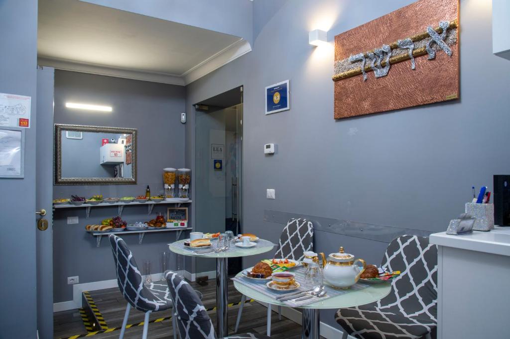 una sala da pranzo con due tavoli e sedie di Lea Luxury Rooms a Roma