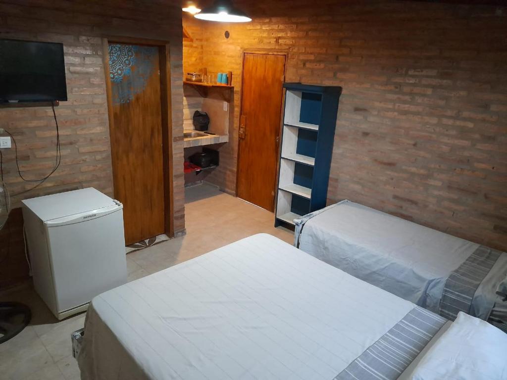 una habitación con 2 camas y TV y una habitación con en EL ZORZAL Dormis con Galeria en Villa del Dique