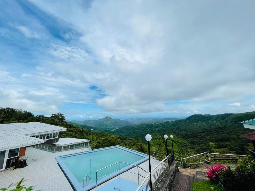 een huis met een zwembad en bergen op de achtergrond bij La View Mountain Resort in Damasanan