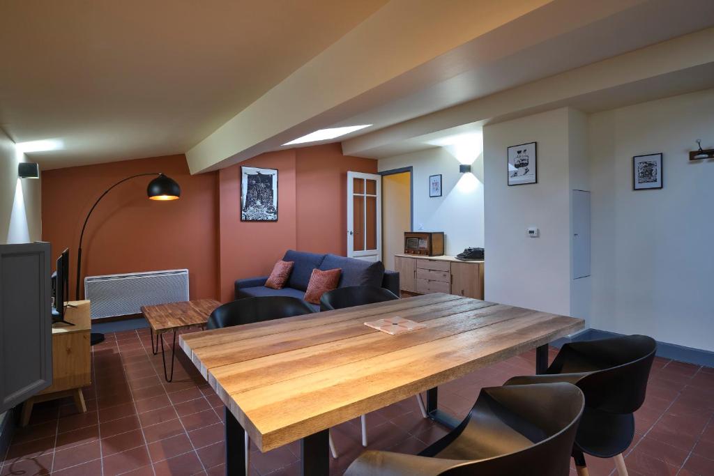- un salon avec une table et des chaises en bois dans l'établissement AUTOUR DU CHATEAU, à Carcassonne
