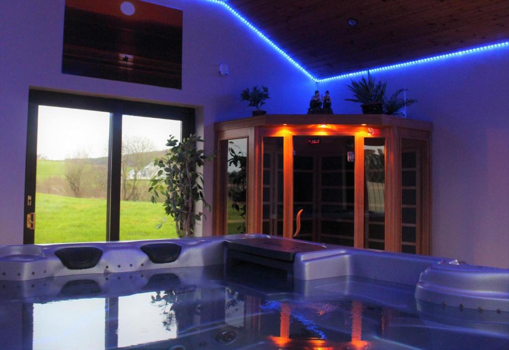 a hot tub in a room with blue lights at Millstone Cottages in Milford