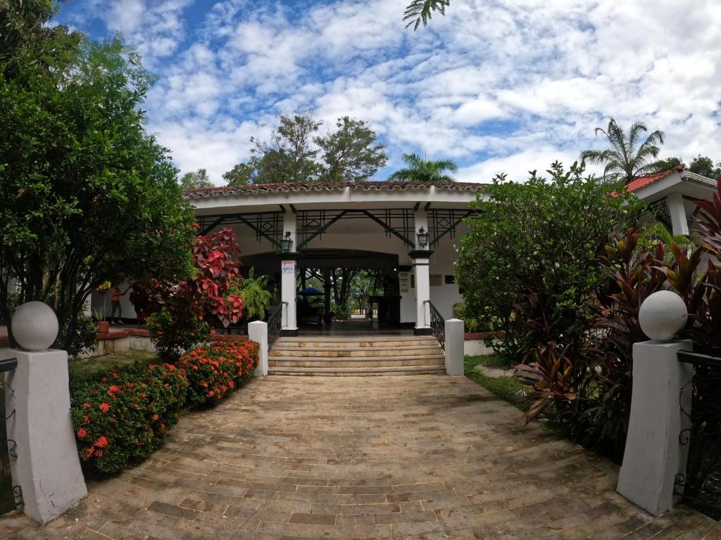 una pasarela que conduce a un edificio con flores en Hotel Matamundo en Neiva