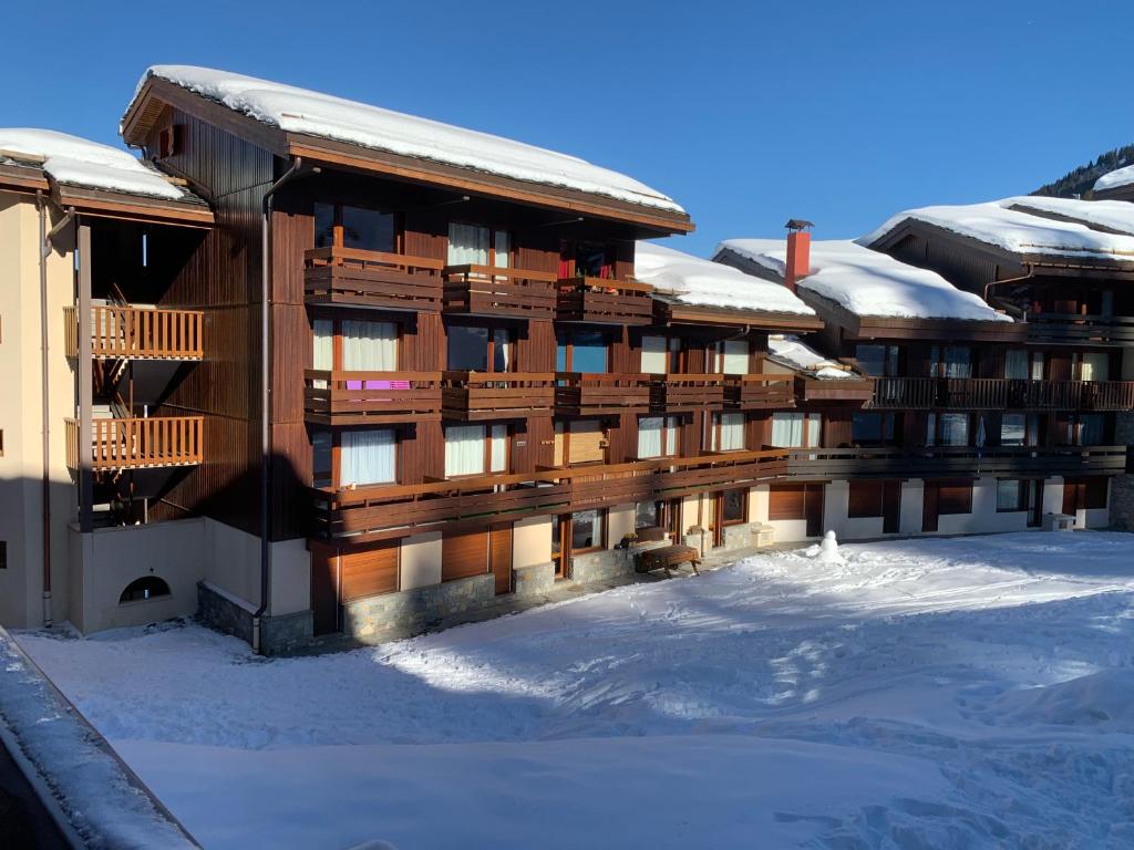 un gran edificio con nieve en el suelo en Appartement Velaer Valmorel, en Valmorel