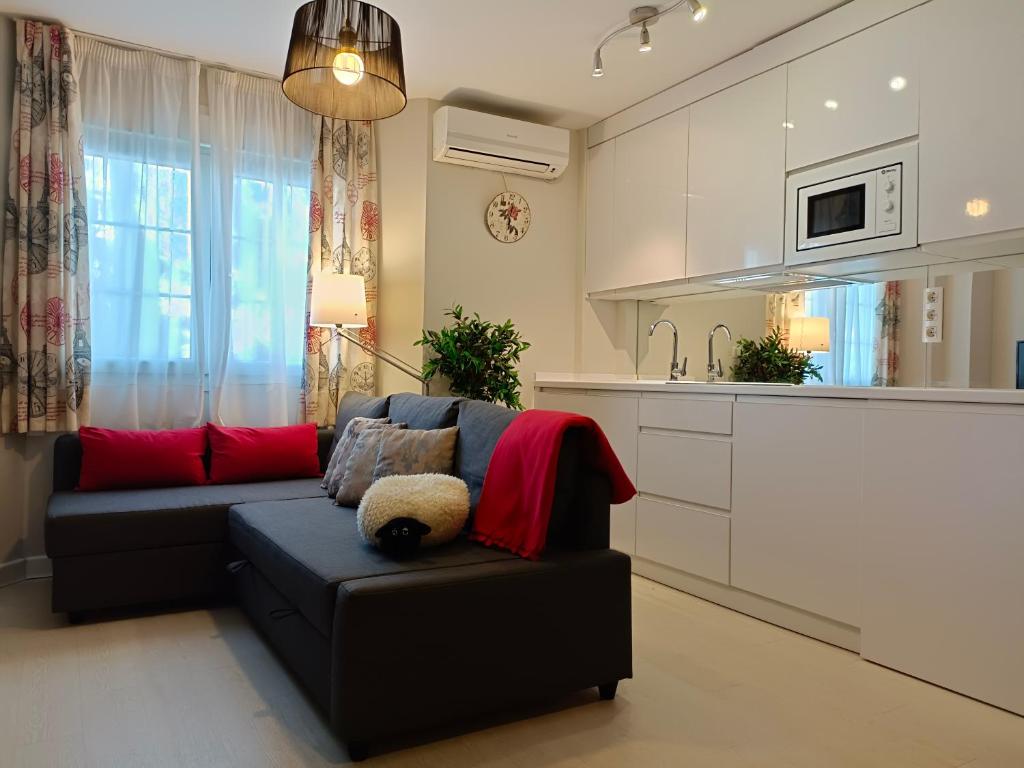 ein Wohnzimmer mit einem Sofa und einer Küche in der Unterkunft Neverending Loft in Málaga