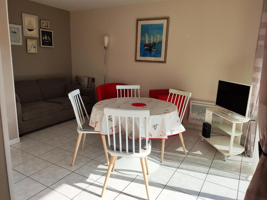 uma sala de estar com uma mesa e cadeiras e um sofá em Hardelot plage plein sud a 100 m de la plage em Neufchâtel-Hardelot