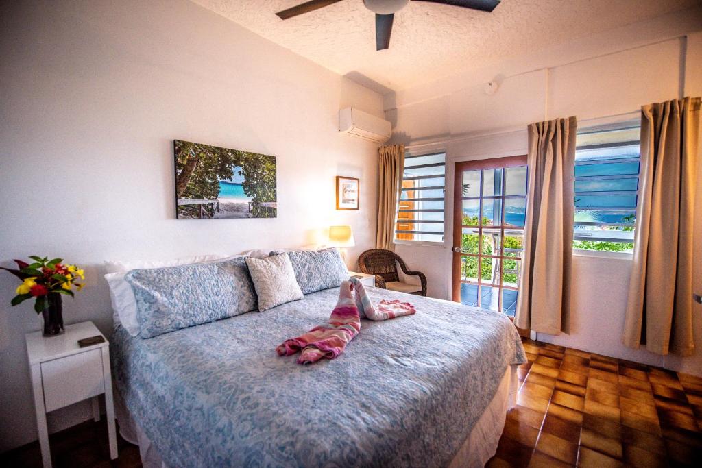 a bedroom with a bed with a pair of shoes on it at Papaya Suite at Sunset Serenade in Enighed
