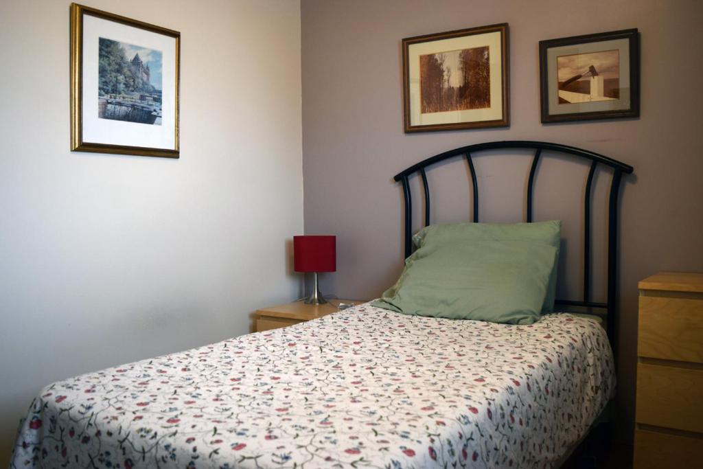 a bedroom with a bed and two pictures on the wall at The Dewberry Homestay B&B in Edmonton