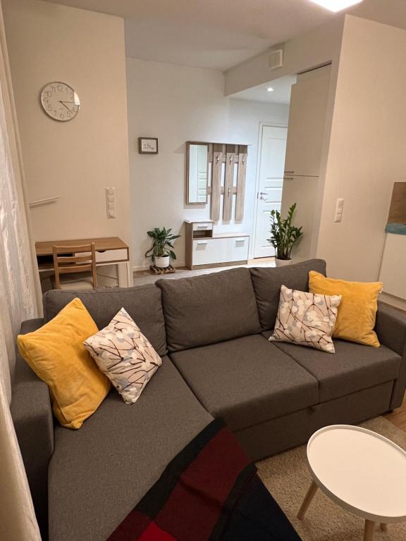 a living room with a gray couch with yellow pillows at Cozy centre apartament Kuopio in Kuopio
