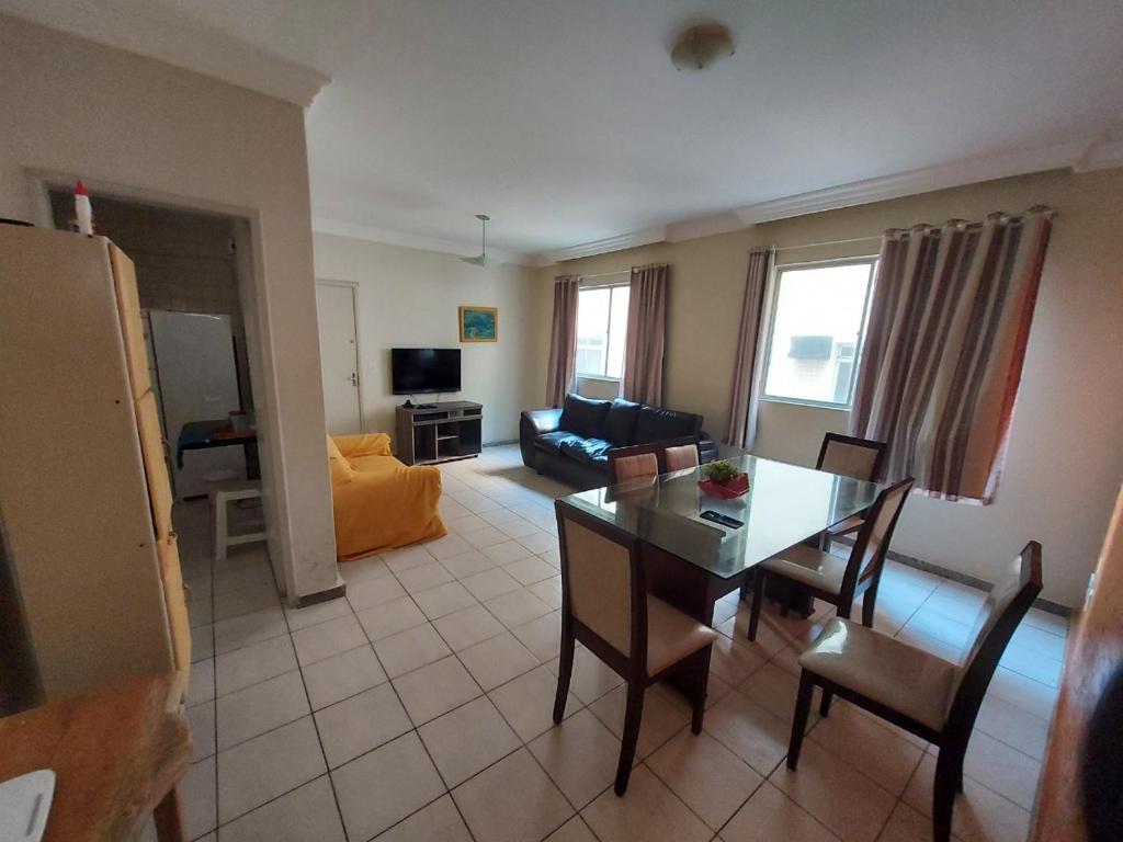 ein Wohnzimmer mit einem Tisch und einem Sofa in der Unterkunft Lindo apartamento 50 metros da praia do morro, três quartos e duas vagas de garagem in Guarapari
