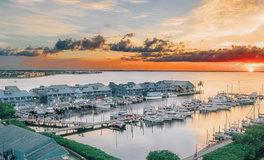 eine Gruppe von Booten, die bei Sonnenuntergang an einem Yachthafen angedockt sind in der Unterkunft The Suites at Fishermen's Village - 2 Bedroom Suites in Punta Gorda