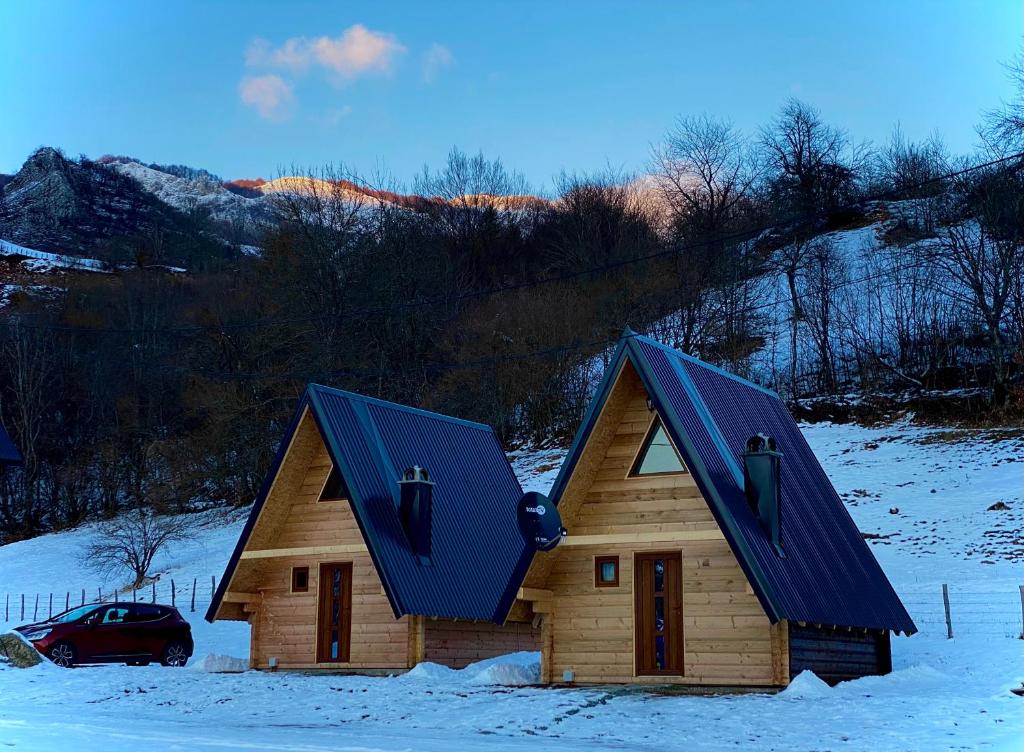 a wooden house with a blue roof in the snow at BB CHALET in Kolašin