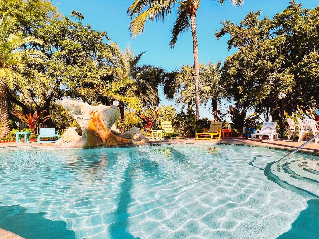 a swimming pool in a resort with palm trees at The Ocean View Inn in Islamorada