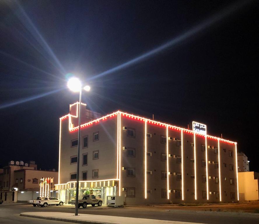 ein Gebäude mit Straßenbeleuchtung davor in der Unterkunft شقق الكادي in Najran