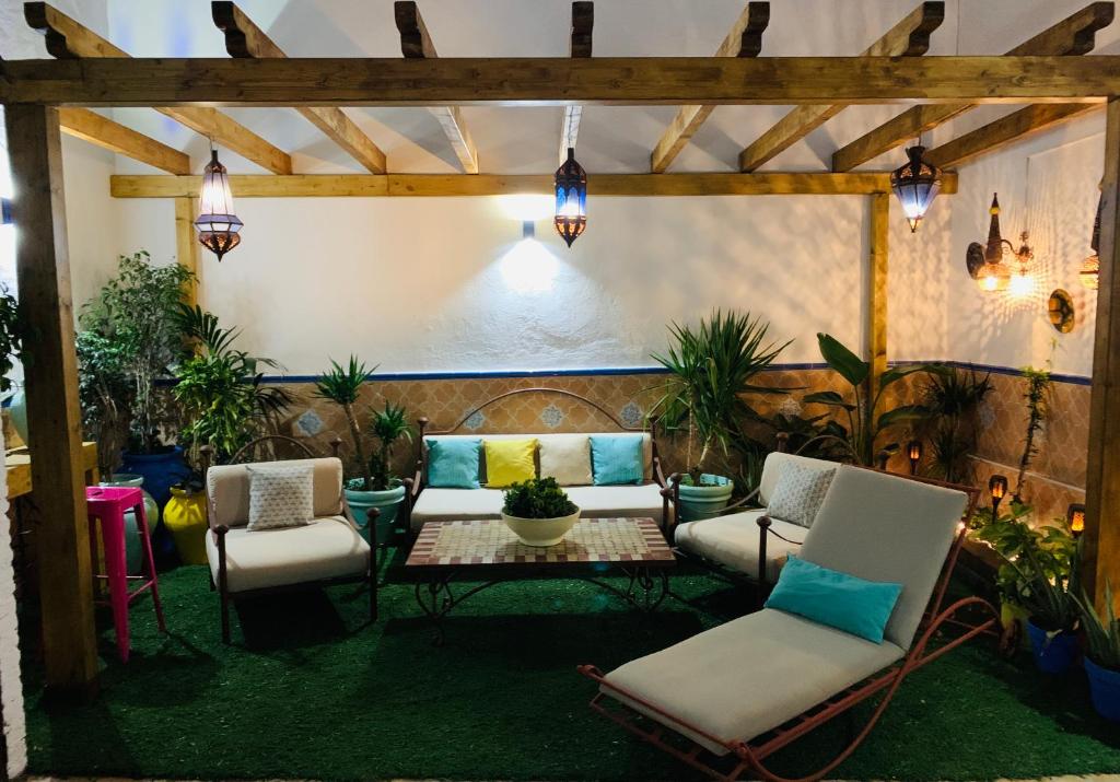 eine Terrasse mit Stühlen, einem Tisch und einem Sofa in der Unterkunft Casa Pepita Gutiérrez in Sevilla