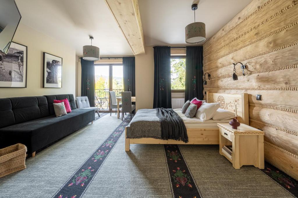a living room with a bed and a couch at Highlander Heart Residence in Zakopane
