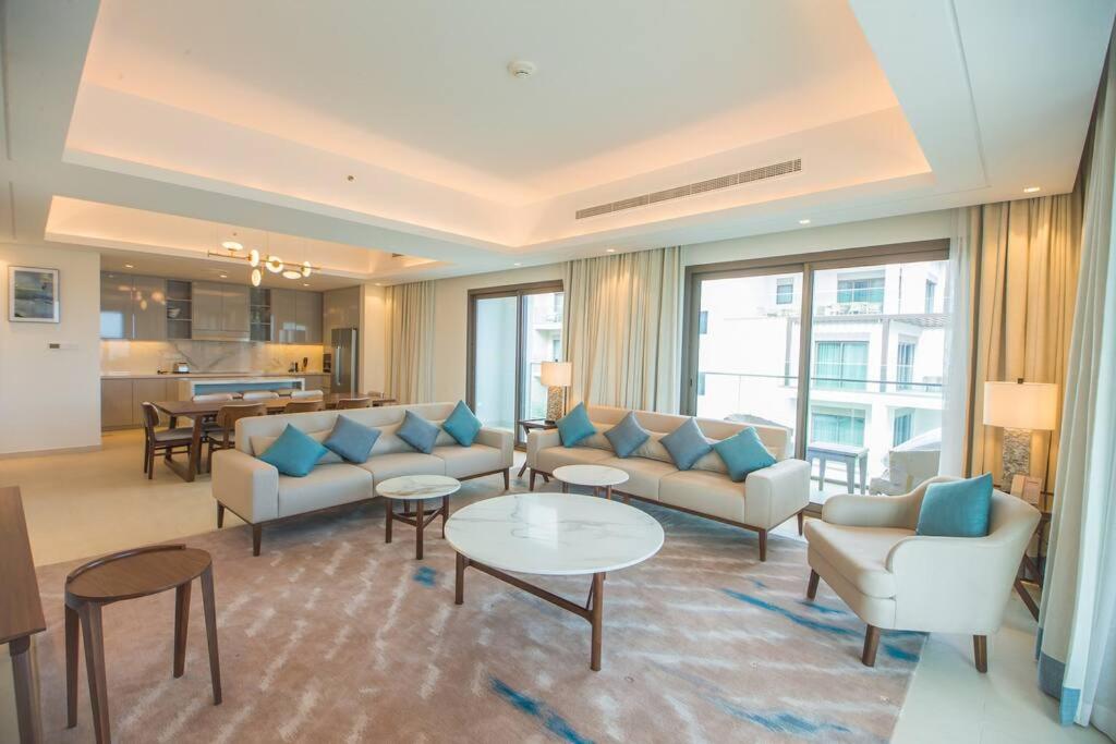 a living room with couches and tables and a kitchen at Luxurious 5 Bedroom Apartment - Full Ocean view in Al Aqah