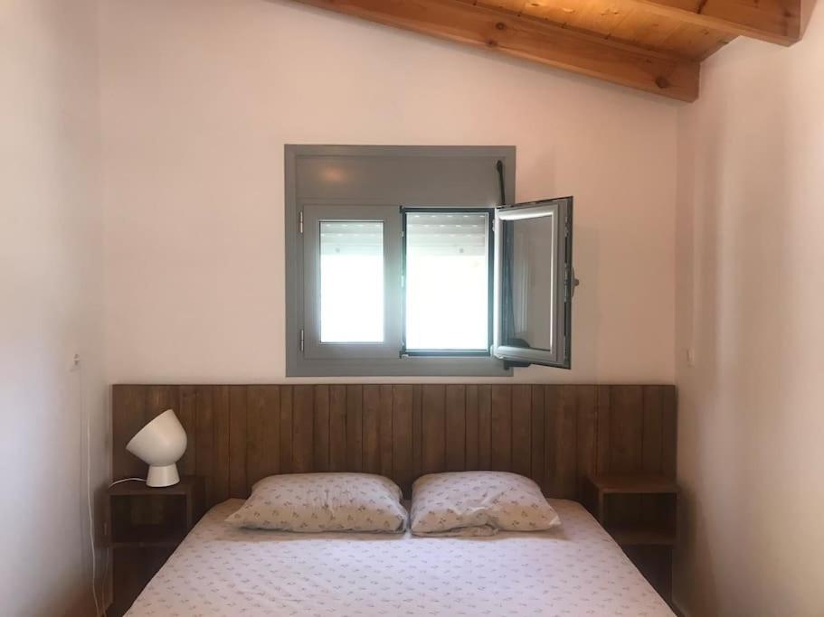 a bedroom with a bed with a mirror above it at Πέτρινη κατοικία στην Αίγινα - Stone House in Aigina in Khlóï