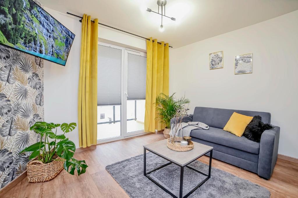 ein Wohnzimmer mit einem Sofa und einem Tisch in der Unterkunft Apartament na Zlotej Podkowie in Głogów
