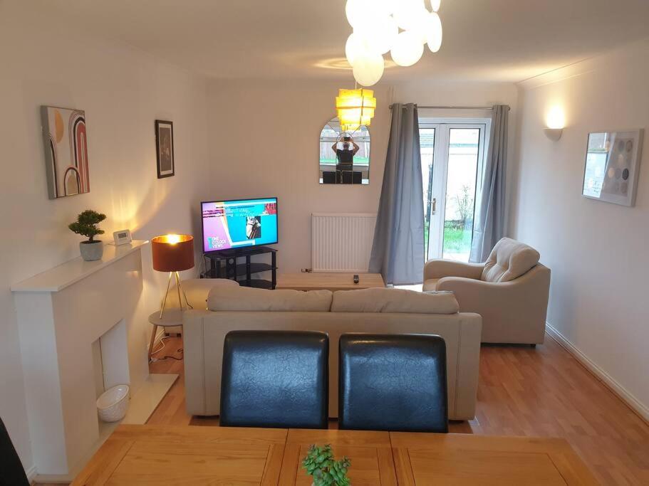 a living room with a couch and a tv at Stylish 3 Bedroom House with Free Parking in Norwich